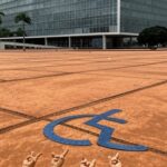Fachada da Câmara Legislativa do DF em Brasília com símbolos de Libras, destacando reconhecimento tardio e falhas na inclusão.