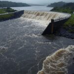 Reservatório do Descoberto transbordando em Brasília, expondo riscos de inundações no DF.