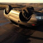 Cena de acidente com capotamento de carro na rodovia DF-001, Distrito Federal, Brasil.