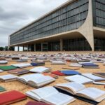 Edifício da CLDF em Brasília com livros desorganizados simbolizando ameaça à estabilidade educacional no DF.