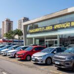 Concessionária de veículos em São Paulo com carros novos expostos, ilustrando crescimento de 9,2% no financiamento de veículos no Brasil.
