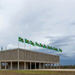 Edifício da Câmara Legislativa do DF em Brasília, com bandeiras e céu nublado, representando concessão de título honorário sob críticas.