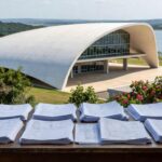 Mesa com pilhas de documentos burocráticos em escritório no DF, representando inscrições para conselho de Caesb e Adasa com burocracia que afasta consumidores.