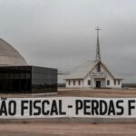 Fachada da Câmara Legislativa do DF com templo religioso ao fundo, representando isenção de taxas e temores de perdas fiscais.