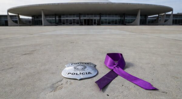 Edifício da CLDF em Brasília com viaturas policiais, simbolizando falhas na segurança e controvérsias sobre violência contra mulheres.