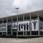 Fachada da CLDF com banners de sindicato de enfermeiros, destacando crise na saúde pública no Brasil.