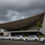 Viatura da Polícia Civil do DF em frente ao Congresso Nacional, com documentos de previdência espalhados, simbolizando debate e insatisfações.