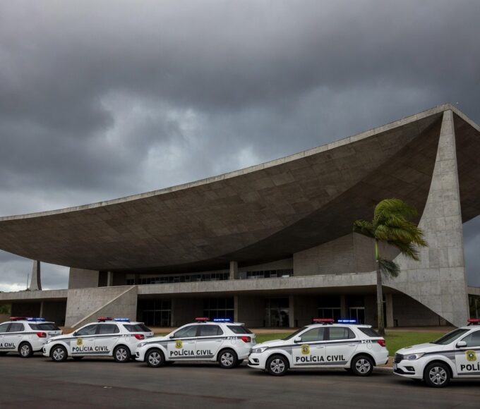 Viatura da Polícia Civil do DF em frente ao Congresso Nacional, com documentos de previdência espalhados, simbolizando debate e insatisfações.