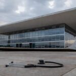 Hospital público deteriorado e viatura policial em Brasília, representando falhas na saúde e segurança do DF.