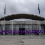Fachada da Câmara Legislativa do DF com fitas roxas simbolizando combate à violência contra mulheres em Brasília.