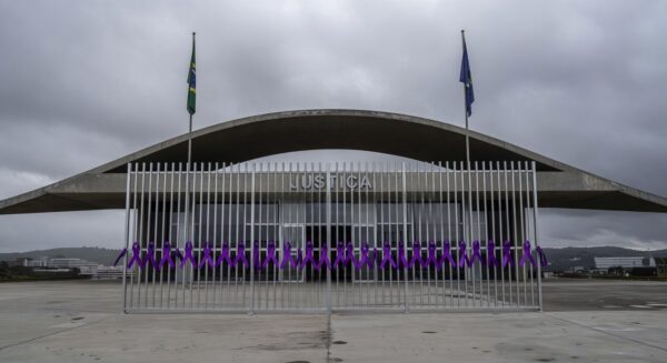 Fachada da Câmara Legislativa do DF com fitas roxas simbolizando combate à violência contra mulheres em Brasília.