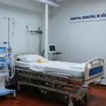 Sala de UTI em hospital brasileiro com equipamentos médicos e cama vazia, representando melhora renal e inflamação em paciente.