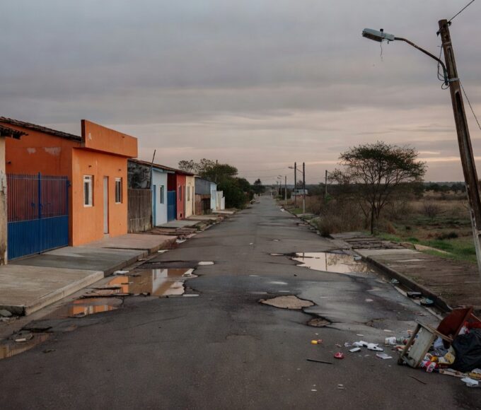 Rua em Riacho Fundo I com casas antigas reformadas tardiamente e problemas de infraestrutura persistentes.