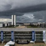 Edifício da CLDF em Brasília com decorações de evento de governança e nuvens escuras ao fundo, representando distração para crises no DF.