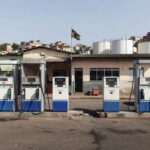 Posto de gasolina no Brasil com bombas de combustível e tanques, representando monitoramento da ANP e debate sobre ICMS.