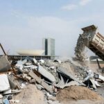 Pilha de entulho sendo removida por caminhão em Brasília, representando remoção de 98 mil toneladas pelo SLU no DF devido a descarte irregular.