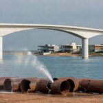 Obras de infraestrutura em Brasília com guindastes e materiais espalhados, indicando lentidão no DF.