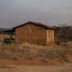 Casa isolada com fita policial em Águas Lindas (GO), cena de crime sem pessoas, representando tragédia familiar.