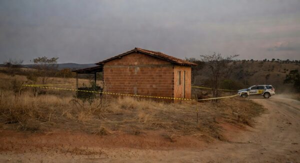 Casa isolada com fita policial em Águas Lindas (GO), cena de crime sem pessoas, representando tragédia familiar.