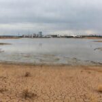 Reservatório de água com nível baixo em Brasília, destacando falhas na segurança hídrica do DF no aniversário da Caesb.