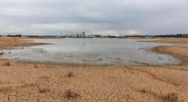 Reservatório de água com nível baixo em Brasília, destacando falhas na segurança hídrica do DF no aniversário da Caesb.