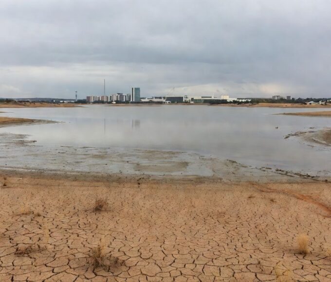 Reservatório de água com nível baixo em Brasília, destacando falhas na segurança hídrica do DF no aniversário da Caesb.