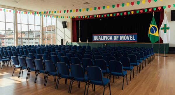 Auditório no Paranoá com palco e banner do QualificaDF Móvel para formatura de alunos.