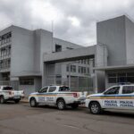 Exterior da prisão Papuda em Brasília com viaturas da Polícia Federal, representando a Operação Compliance Zero.