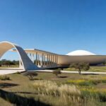 Nova escola integrada em Brasília inspirada na arquitetura modernista local, com linhas curvas e concreto branco.