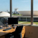 Edifício da CLDF em Brasília com mesa de computadores sugerindo investigação de grampo eletrônico.