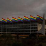 Congresso Nacional em Brasília com bandeira arco-íris e sombras representando discriminação no DF