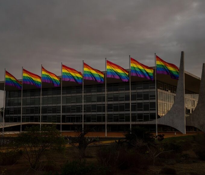 Congresso Nacional em Brasília com bandeira arco-íris e sombras representando discriminação no DF