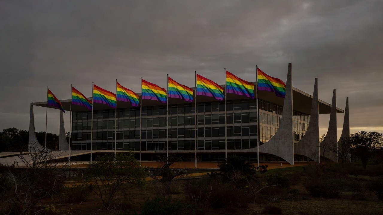 Congresso Nacional em Brasília com bandeira arco-íris e sombras representando discriminação no DF