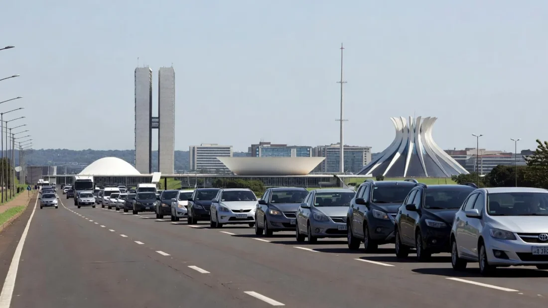 Carreata em rodovia no DF com skyline de Brasília ao fundo