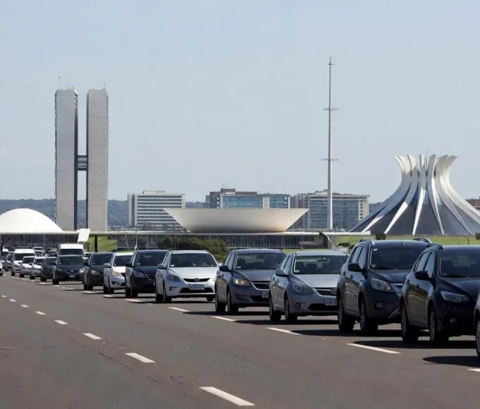 Carreata em rodovia no DF com skyline de Brasília ao fundo